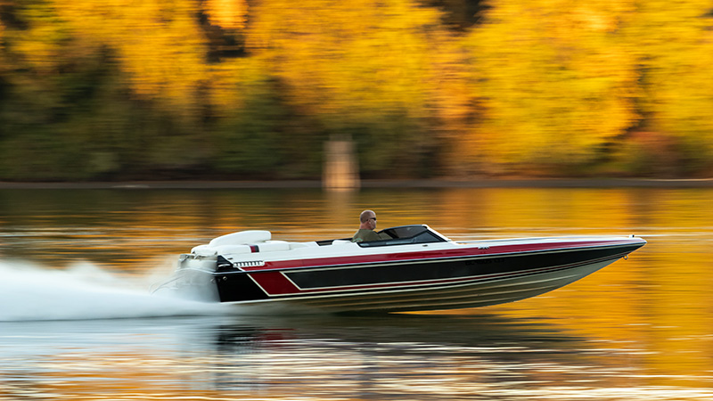 Man driving motorboat in fall